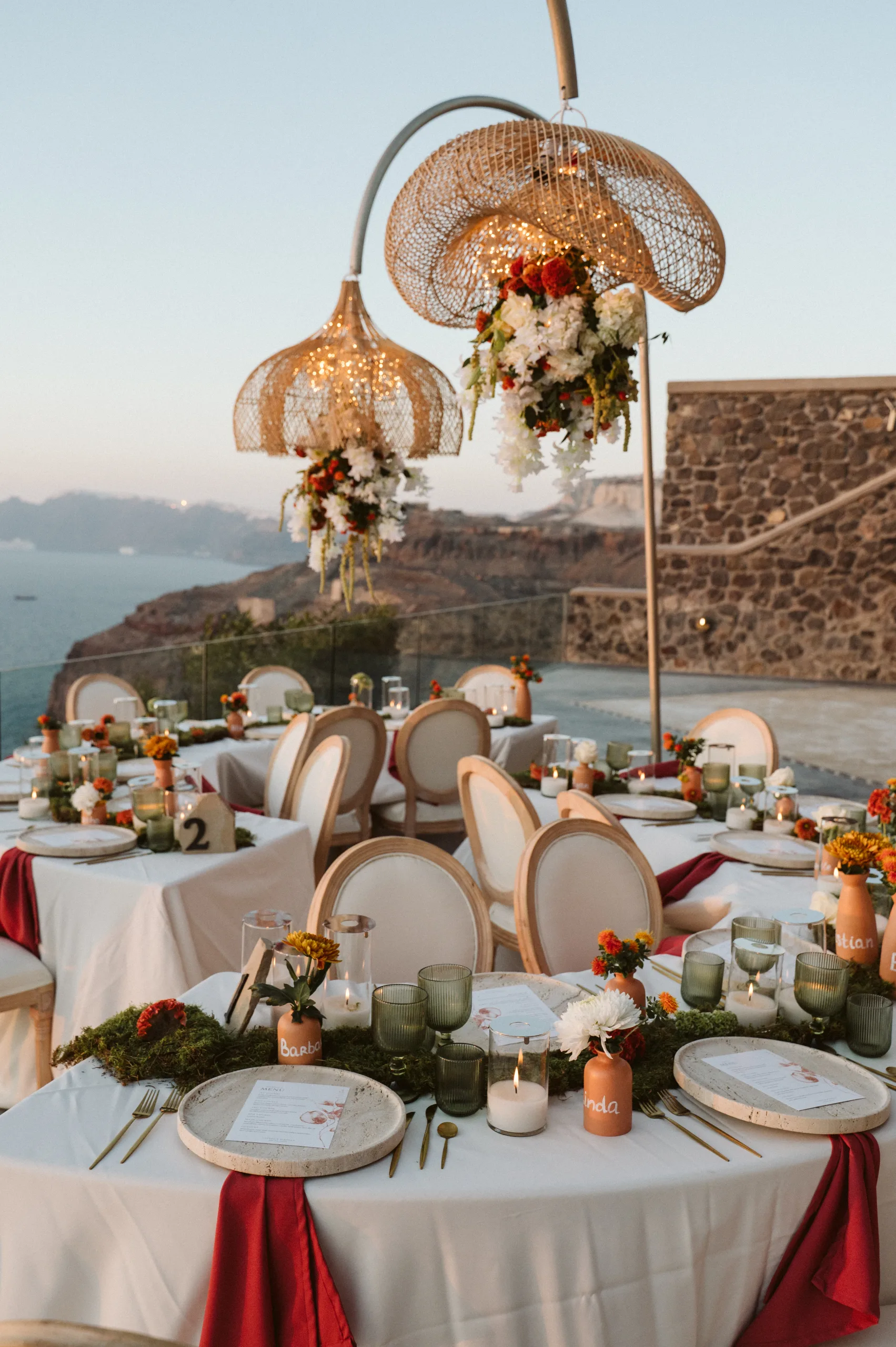 Wedding reception table with crystal chandeliers above the Santorini caldera