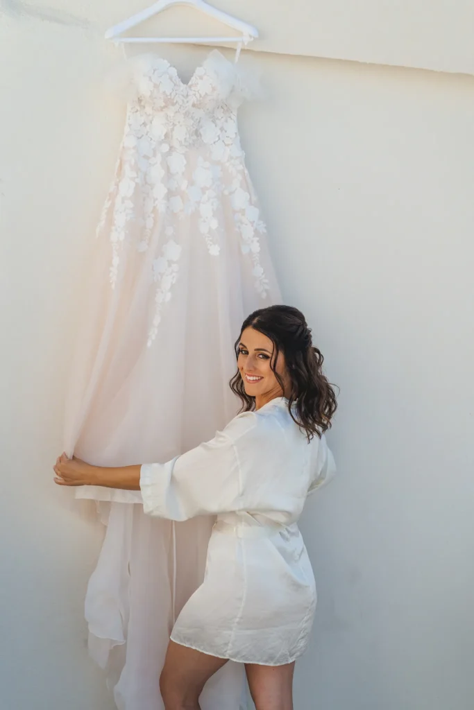 Elisa & Diego wedding at Astra Chapel & 5 Senses Restaurant, Santorini — the dress waiting on the wall