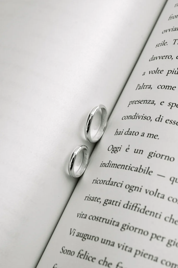 Elisa & Fabio wedding at Love Cave Venue, Santorini — the rings resting on the pages of their vows