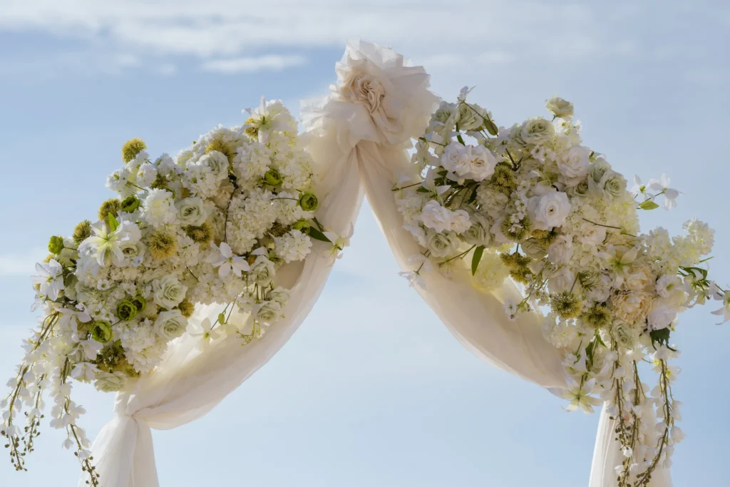 Holly & Taylor wedding at Love Cave Venue, Santorini — the arch draped in ivory with white roses