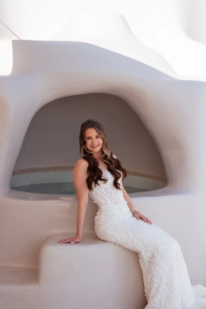 Holly & Taylor wedding at Love Cave Venue, Santorini — the bride in a whitewashed alcove