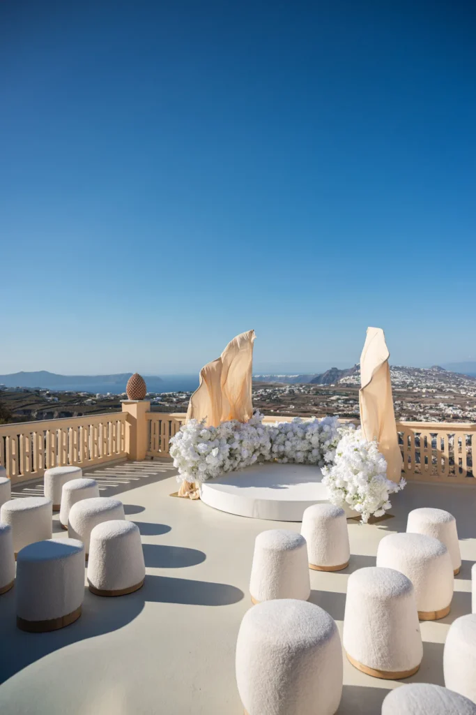 Kirsty & Julian wedding at Madame Sousou, Santorini — the circular stage and its white ottomans