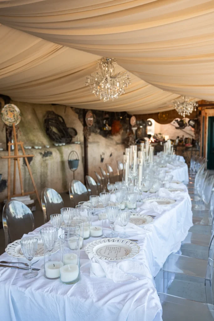 Kirsty & Julian wedding at Madame Sousou, Santorini — the long table laid in white before the guests arrive