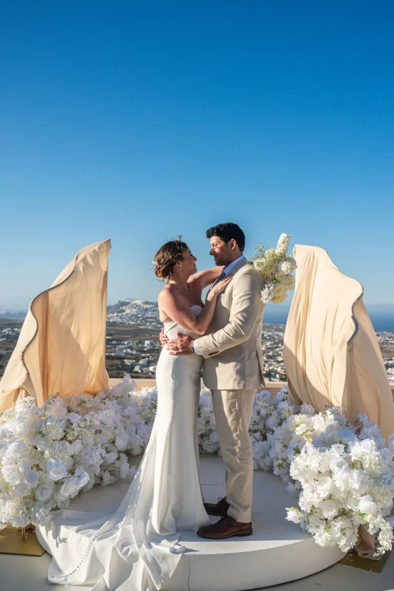 Kirsty & Julian wedding at Madame Sousou, Santorini — the couple between the draped silk arches