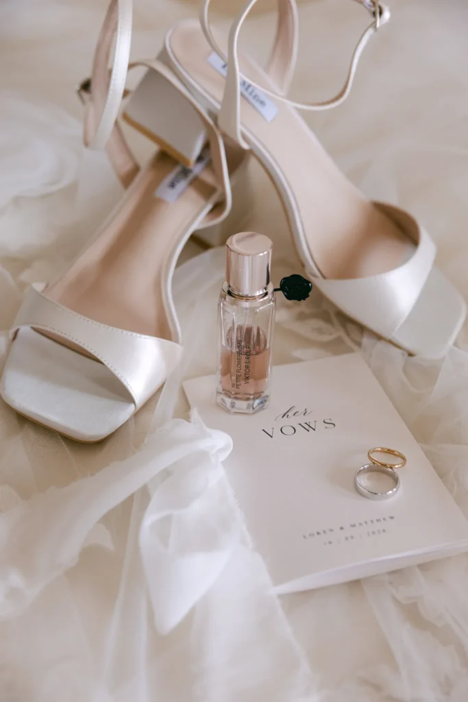 Loren & Matt wedding at Love Cave Venue, Santorini — her heels, perfume, rings and vow books